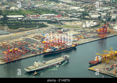 Sydney Australia,Banksmeadow,Port of Botany Bay,shipping,lifting cranes,cargo container ship,aerial overhead view from above,tugboat,AU140312072 Stock Photo
