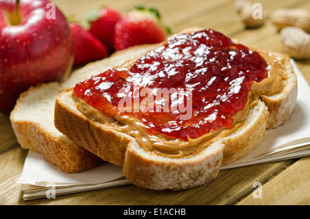 A nutritious peanut butter and jelly sandwich with apples, strawberries, and peanuts. Stock Photo
