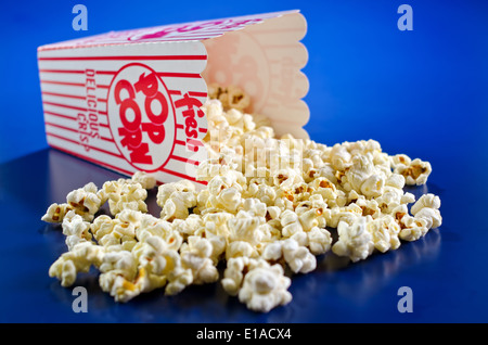 Freshly popped popcorn against a vivid blue background. Stock Photo