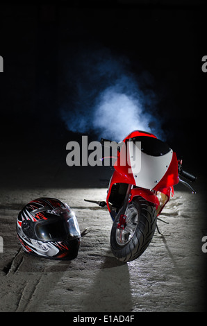 Photograph of a mini moto in a disused warehouse with a black background. Stock Photo