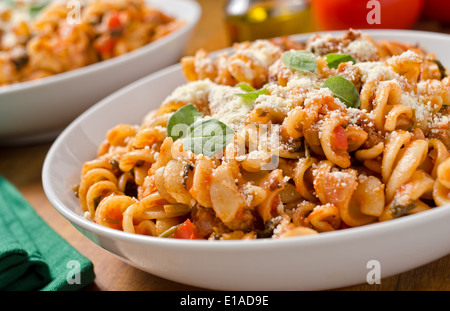 Rotini pasta with marinara sauce, parmesan cheese, and fresh basil. Stock Photo