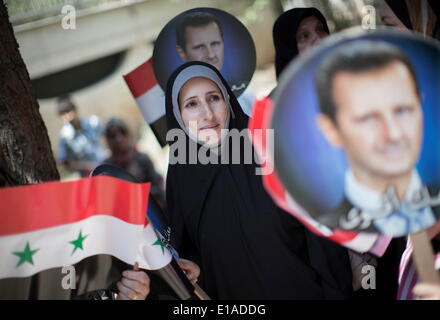 Tehran, Iran. 28th May, 2014. A Syrian woman living in Iran looks on while standing next to the flags and portraits of the Syrian President BASHAR AL-ASSAD, after cast her vote during the 2014 Syria's Presidential election at a pooling station in the Syrian embassy building in northern Tehran. © Morteza Nikoubazl/ZUMA Wire/ZUMAPRESS.com/Alamy Live News Stock Photo