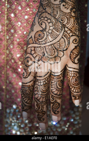 Indian bride to be getting her arms and legs decorated with henna at a vidhi celebration, Ontario, Canada. Stock Photo