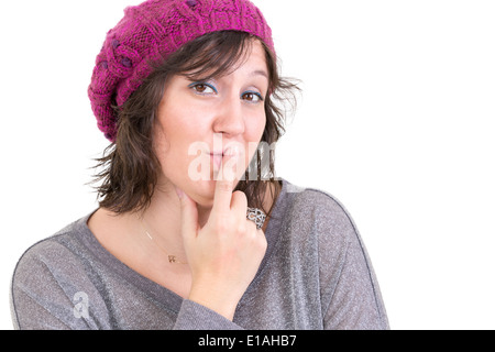 Distrustful skeptical woman with misgivings looking at the camera with a thoughtful assessing look and her finger to her lips Stock Photo