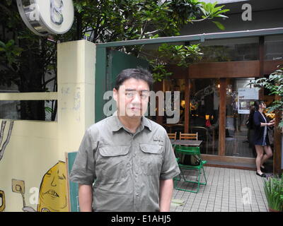Taipeh, Taiwan. 11th May, 2014. Former student leader Wuer Kaixi stans in front of a cafe in Taipeh, Taiwan, 11 May 2014. Kaixi was one of the leaders of the student protests that took place on Tiananmen Square in Bejing, China, some 25 years ago. Wuer currently lives in Taipeh in exile. Photo: Andreas Landwehr/dpa/Alamy Live News Stock Photo