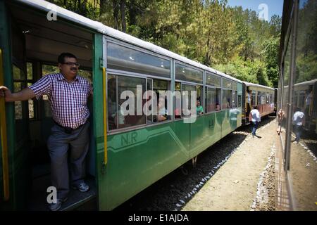 (140529) -- HIMACHAL PRADESH, May 29, 2013 (Xinhua) -- Passengers are seen in a train on the Kalka-Shimla Railway in north India's Himachal Pradesh, May 28, 2014. The Kalka-Shimla Railway is a 762?mm narrow gauge railway in North-West India's Himachal Pradesh travelling along a mostly mountainous route from Kalka to Shimla. It is known for dramatic views of the hills and surrounding villages. The 96-km long railway was built since 1898 to provide a service to the highland town of Shimla. Three still fully operational railways, the Darjeeling Himalayan Railway in India's West Bengal, the Nilgir Stock Photo