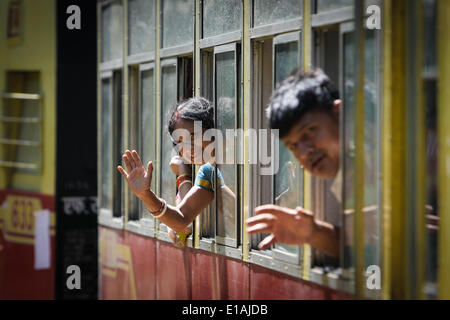 (140529) -- HIMACHAL PRADESH, May 29, 2013 (Xinhua) -- Passengers wave in a train on the Kalka-Shimla Railway in north India's Himachal Pradesh, May 28, 2014. The Kalka-Shimla Railway is a 762?mm narrow gauge railway in North-West India's Himachal Pradesh travelling along a mostly mountainous route from Kalka to Shimla. It is known for dramatic views of the hills and surrounding villages. The 96-km long railway was built since 1898 to provide a service to the highland town of Shimla. Three still fully operational railways, the Darjeeling Himalayan Railway in India's West Bengal, the Nilgiri Mo Stock Photo