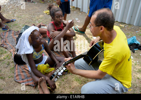 Social worker, musician, giving street children guitar lessons and singing with them at Central do Brasil railway station Stock Photo