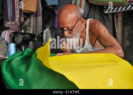 Dhaka, May 29. 12th June, 2014. A tailor sews a Brazilian national flag ahead of the upcoming 2014 FIFA World Cup in Dhaka, Bangladesh, May 29, 2014. The 2014 FIFA World Cup International Football tournament will kick off in Brazil on June 12, 2014. © Shariful Islam/Xinhua/Alamy Live News Stock Photo