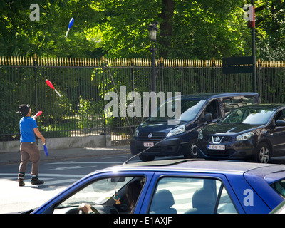 Man trying to entertain waiting car drivers with a juggling act near the Warande Park in Brussels, Belgium Stock Photo