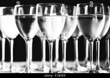 Row of water glasses. Pure drinking water. Black and white picture. Selective focus. Stock Photo