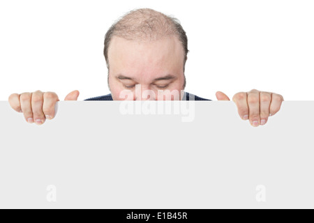 Businessman holding a blank white sign suitable for advertising looking down with closed eyes and hiding his face behind the boa Stock Photo