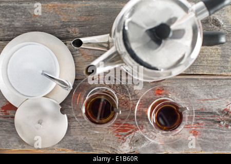 View from above showing the preparation of two hot glasses of Turkish tea using the traditional stacked kettles on an old rustic Stock Photo