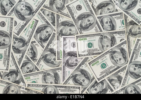 Hundreds of new Benjamin Franklin 100 dollar bills arranged randomly with the portrait facing uppermost in a closeup conceptual Stock Photo