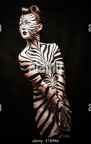 A woman with her body painted in black and white zebra stripes