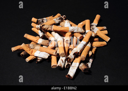 Pile of used cigarette butts on black background Stock Photo