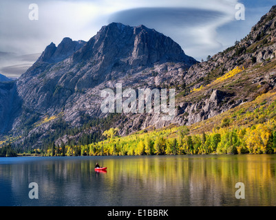 Silver Lake reflection with fall colored cottonwood trees and boat with fisherman at sunrise.California Stock Photo