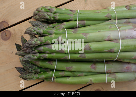green asparagus lying on a wooden table Stock Photo
