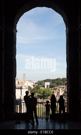 Visitors looking out at the Roman forum through an arch in the Musei Capitolini, Rome Italy, Europe Stock Photo