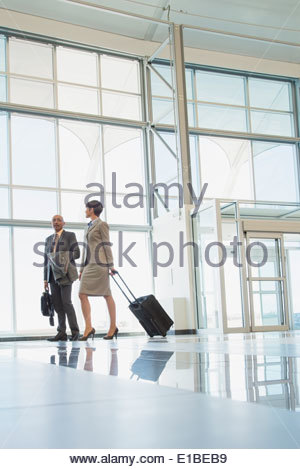 Business people with suitcases in modern lobby