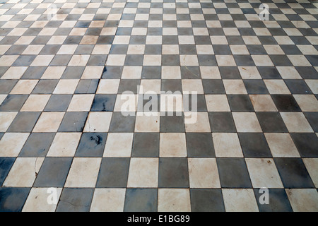 Close up of antique ceramic checkerboard tiled flooring with light shining across Stock Photo