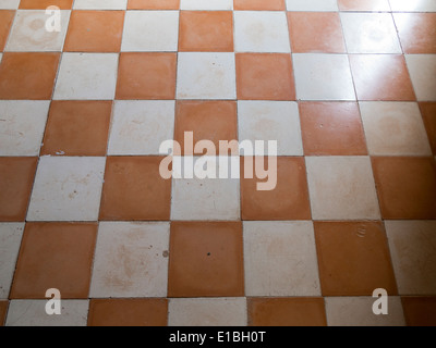 Close up of antique ceramic checkerboard tiled flooring with light shining across Stock Photo