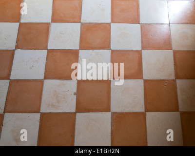 Close up of antique ceramic checkerboard tiled flooring with light shining across Stock Photo