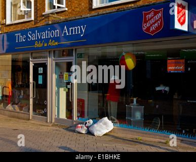 Bags of donated clothing left outside a Salvation Army high street charity shop in Redhill Surrey England UK Stock Photo