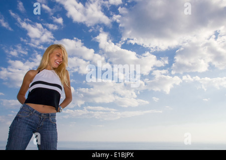 beautiful woman in front of sky next to sea Stock Photo