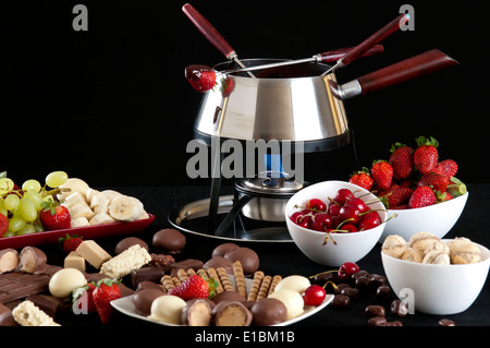 Fondue melted chocolate dip with different flavors on black background Stock Photo
