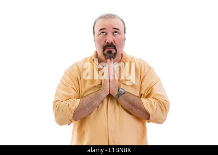 Religious man praying to God with his hands clasped as he seeks help with his eyes raised to heaven, part of a series on body la Stock Photo
