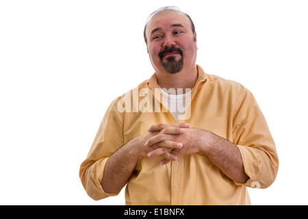Happy overweight middle-aged man with a goatee clasping his hands over his chest and glancing sideways with a complacent express Stock Photo