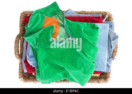 Clean fresh washed summer clothes in a basket neatly folded and viewed from above with a colorful green shirt on top of the pile Stock Photo