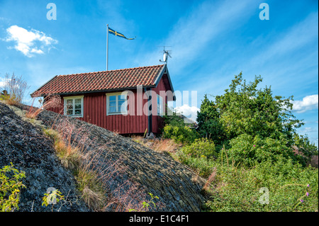 Summer in Sweden – traditional red little cottage at Harstena island in the Baltic sea  A former fishing village in the archipel Stock Photo