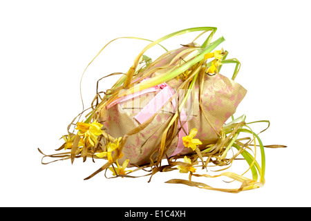 decorative paper covered pot of dying yellow daffodils Stock Photo