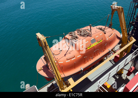 Red rescue boat hanging on the passenger ship Stock Photo