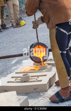 Pouring molten iron to make a sculpture. Stock Photo