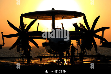 U.S. Sailors assigned to the ?Sun Kings? of Airborne Early Warning Squadron 116 work on an E-2C Hawkeye aircraft aboard the air Stock Photo