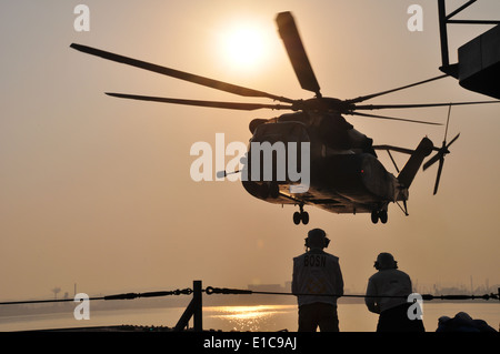 U.S. Navy Chief Warrant Officer Steve Metham and Senior Chief Damage Controlman David Hernandez observe as an MH-53E Super Stal Stock Photo