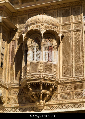 India, Rajasthan, Jaisalmer, Patwon Ki Haveli carved sandstone projecting window balcony with wooden shutters Stock Photo