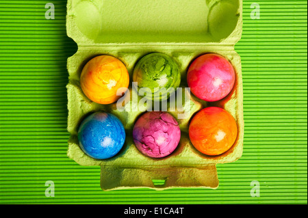 six colorful eggs in carton box Stock Photo