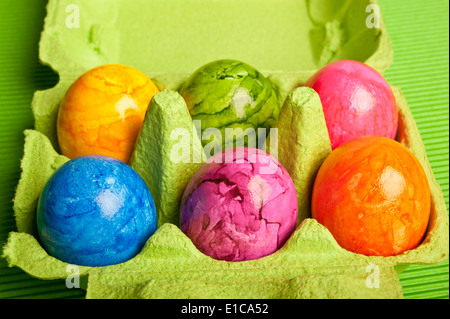 six colorful eggs in carton box Stock Photo