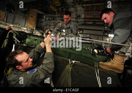 U.S. Air Force Staff Sgt. Richard Miner , left, works with Army Specialists Jordan Markelwitz , right, and Daniel Rocco, to loa Stock Photo