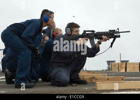 U.S. Navy Fire Controlman 2nd Class Chaung Pha observes as Hull Technician 2nd Class Donipaul Briscoe fires an M-16 rifle durin Stock Photo