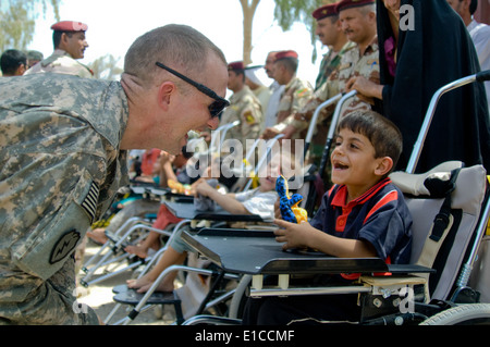 U.S. Army Capt. John Turner, of Alpha Battery, 2nd Battalion, 8th Field Artillery Regiment, interacts with an Iraqi child on Fo Stock Photo