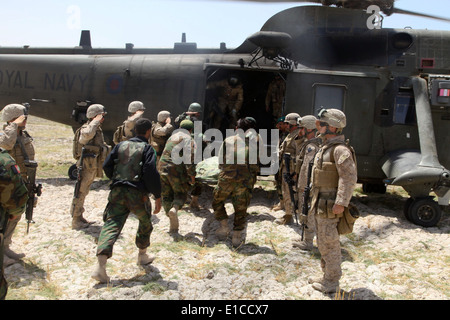 Afghan National Army soldiers load a fallen soldier into a British Royal Navy SH-3H Sea King helicopter as U.S. Marines from 1s Stock Photo