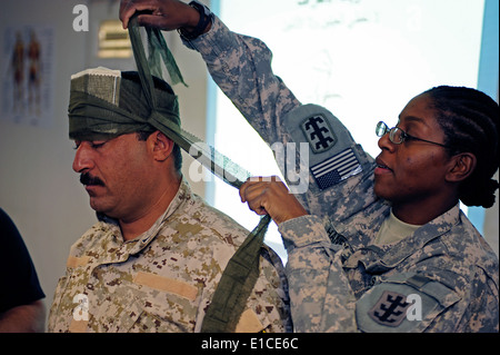 U.S. Army Spc. Lisa Haney demonstrates to Iraqi soldiers how to dress a head wound during a combat lifesavers course on Conting Stock Photo