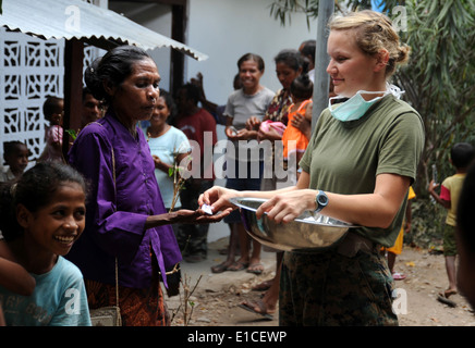U.S. Navy Petty Officer 2nd Class Rachel Arndt, assigned to the 11th Marine Expeditionary Unit, hands out toothpaste at a clini Stock Photo