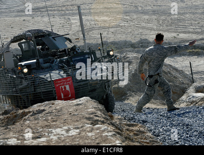 U.S. Army Staff Sgt. Adam Turcotte with 8th Battalion, 1st Cavalry, 5th Brigade, 2nd Infantry, directs a Stryker armored vehicl Stock Photo