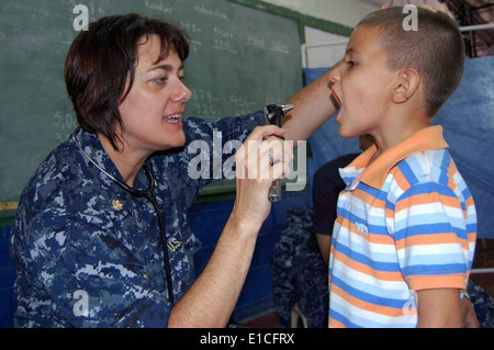 U.S. Navy Lt. Cmdr. Kelly Hamon, embarked aboard the Military Sealift Command hospital ship USNS Comfort (T-AH 20), examines a Stock Photo